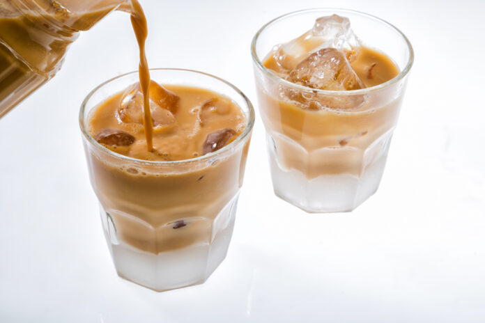 Pouring,Tea,To,Glass,With,Ice,Isolated,On,White,Background